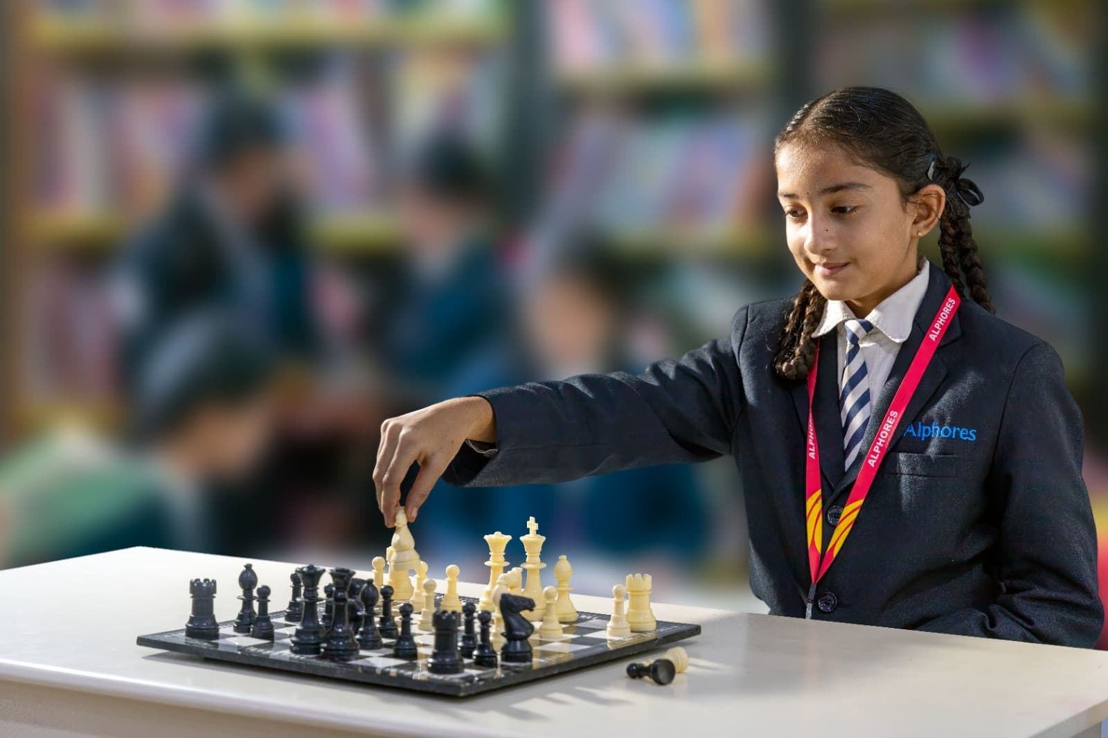 An Alphores student playing chess in the library